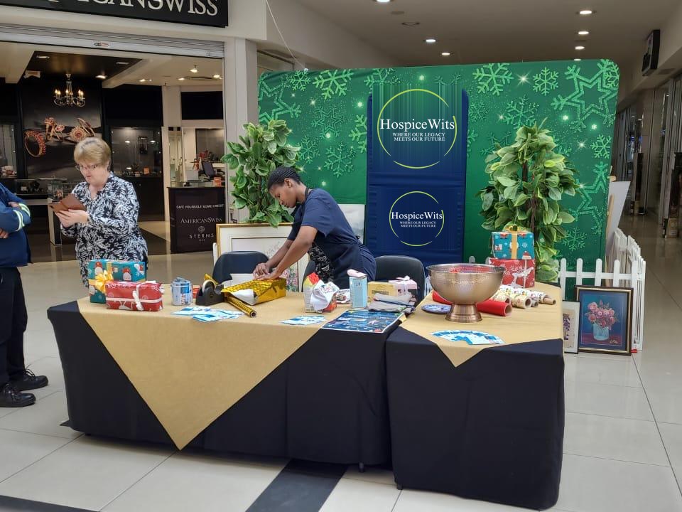 A HospiceWits gift-wrapping table at a shopping centre, raising funds for patient care