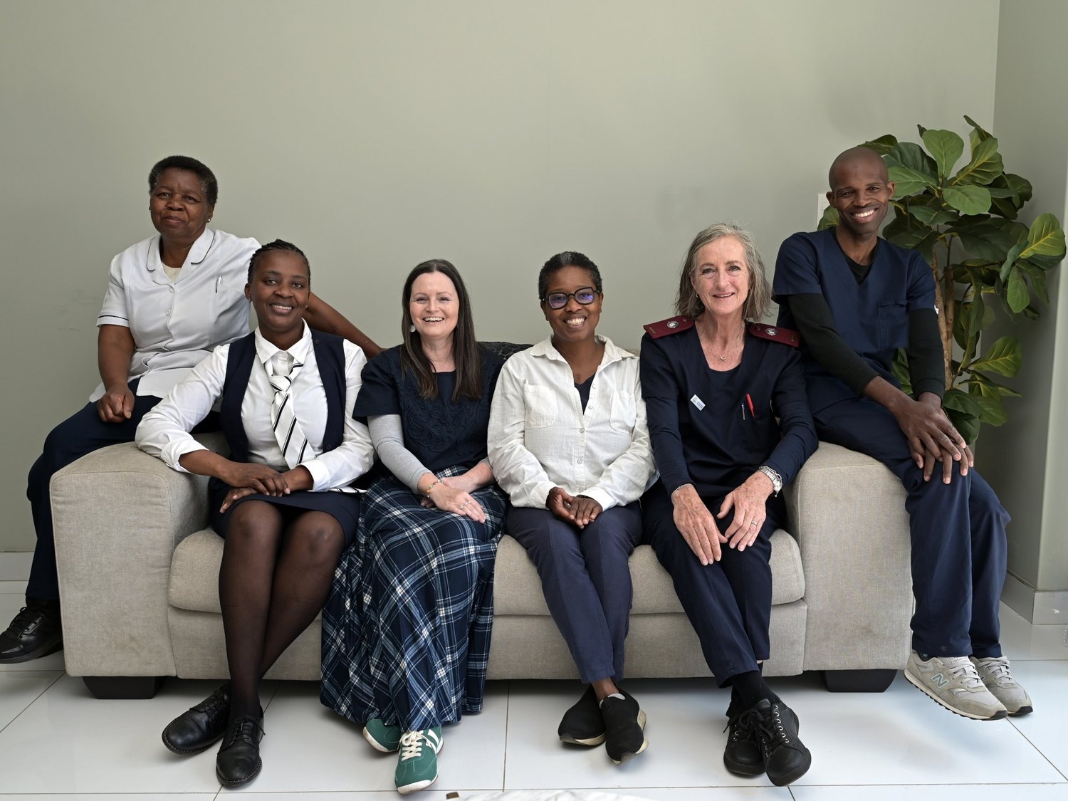 The HospiceWits Inpatient Unit team seated together on a couch in the unit